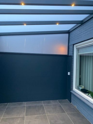 Moderne overdekte ruimte met blauwe muren en verlichting.
